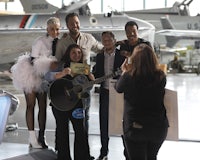 a group of people posing for a photo in front of an airplane