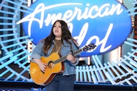 an american idol contestant is holding an acoustic guitar